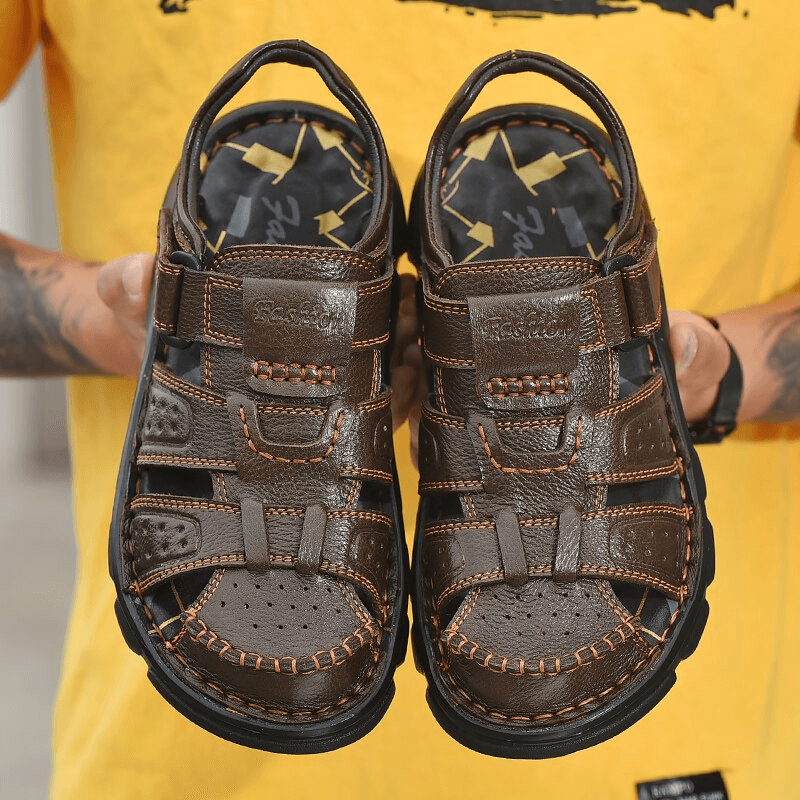 Soft Soles SF1080 genuine leather trekking sandals with anti-collision toes, held by person wearing yellow, ideal for rugged adventures.